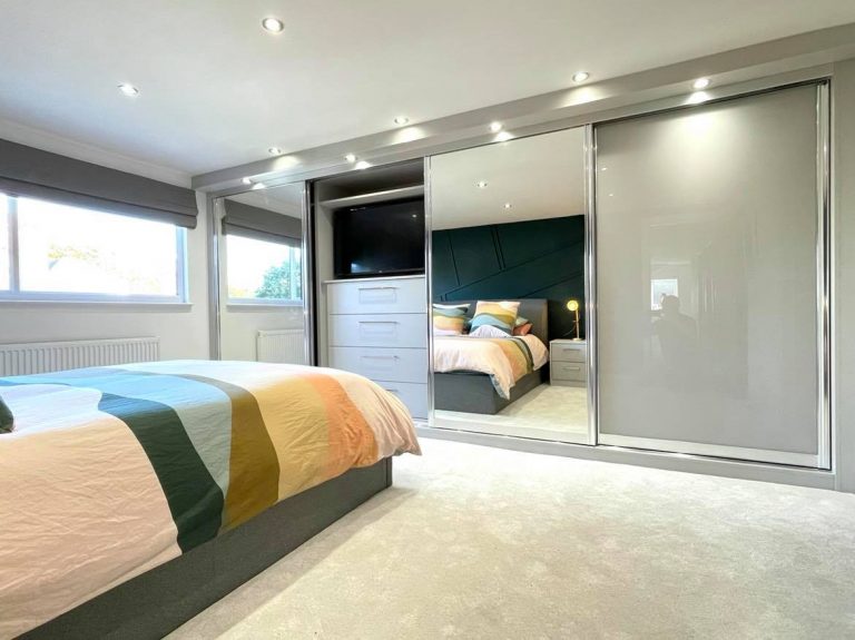 Light Grey & Mirror Sliding Wardrobes With Built in TV Unit by James Kilner in Wakefield
